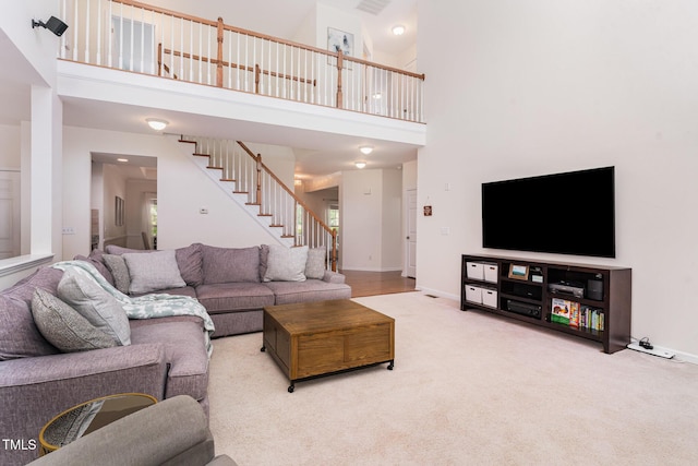 2201 Wide River Dr, Raleigh, NC 27614 - carpeted living room featuring stairway and a towering ceiling