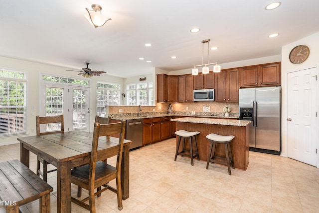 2201 Wide River Dr, Raleigh, NC 27614 - kitchen featuring stainless steel appliances, a ceiling fan, a center island, decorative backsplash, and recessed lighting