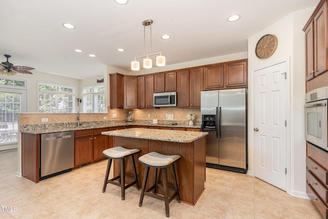 2201 Wide River Dr, Raleigh, NC 27614 - kitchen featuring appliances with stainless steel finishes, recessed lighting, decorative backsplash, a peninsula, and light stone counters