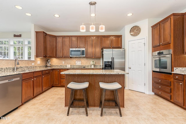 2201 Wide River Dr, Raleigh, NC 27614 - kitchen with stainless steel appliances, a kitchen island, decorative backsplash, light stone countertops, and recessed lighting