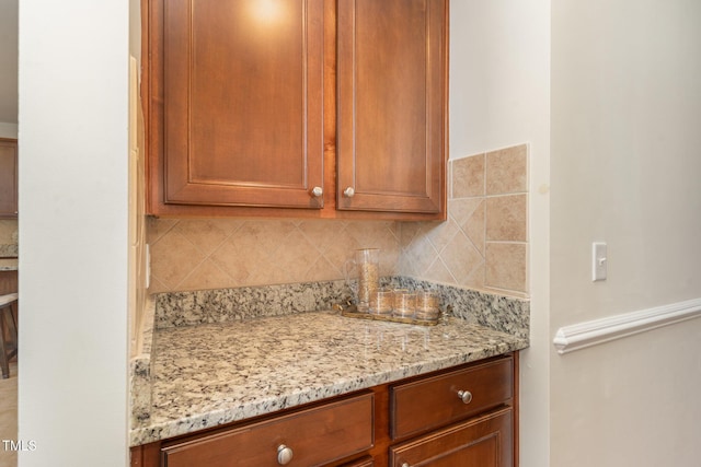 2201 Wide River Dr, Raleigh, NC 27614 - kitchen with tasteful backsplash, light stone countertops, and brown cabinetry