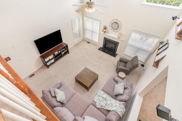 2201 Wide River Dr, Raleigh, NC 27614 - living area with a towering ceiling, carpet floors, a ceiling fan, and a fireplace with flush hearth