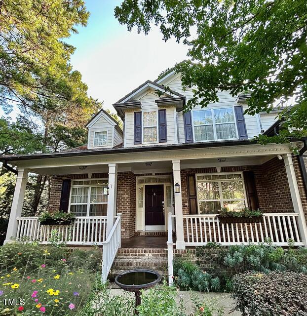 12212 Ashton Woods Ln, Raleigh, NC 27614 - traditional-style home featuring covered porch and brick siding
