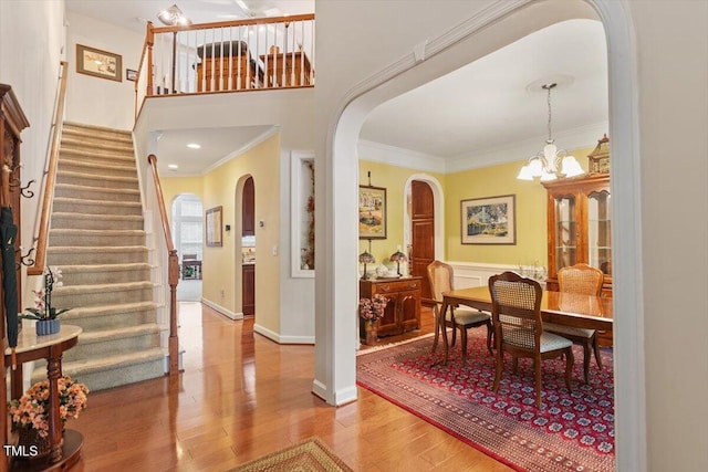 12212 Ashton Woods Ln, Raleigh, NC 27614 - entryway with arched walkways, stairs, wood finished floors, a chandelier, and ornamental molding