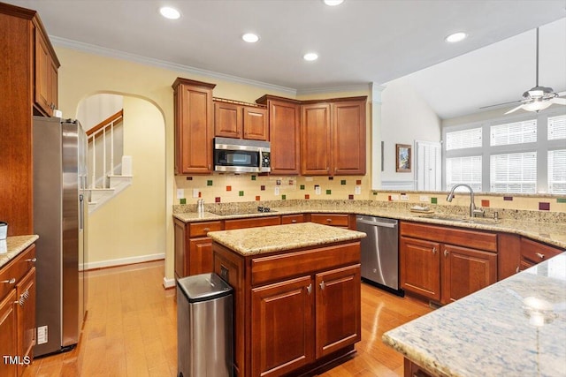 12212 Ashton Woods Ln, Raleigh, NC 27614 - kitchen with stainless steel appliances, arched walkways, ceiling fan, decorative backsplash, and ornamental molding