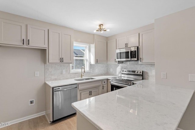 407 E Williams St, Angier, NC 27501 - kitchen featuring appliances with stainless steel finishes, a peninsula, light stone countertops, and tasteful backsplash