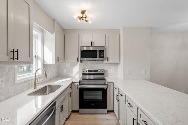 407 E Williams St, Angier, NC 27501 - kitchen with stainless steel appliances, light stone counters, backsplash, and light wood-type flooring