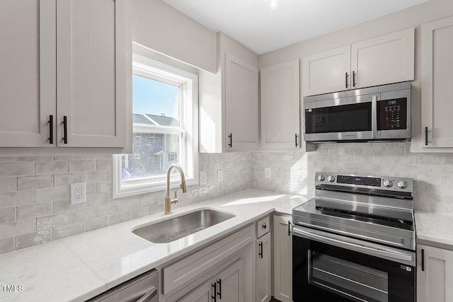 407 E Williams St, Angier, NC 27501 - kitchen with stainless steel appliances, light stone counters, backsplash, and white cabinetry