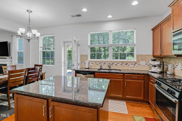 118 Tweedbank Ct, Fuquay Varina, NC 27526 - kitchen with stainless steel appliances, light wood finished floors, a center island, dark stone countertops, and recessed lighting