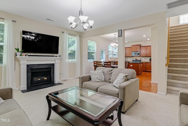 118 Tweedbank Ct, Fuquay Varina, NC 27526 - living room with a chandelier, stairway, light colored carpet, a fireplace with flush hearth, and recessed lighting