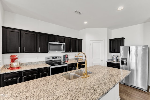 133 Ogden Pond Pl, Zebulon, NC 27597 - kitchen with appliances with stainless steel finishes, dark cabinets, wood finished floors, recessed lighting, and light stone countertops