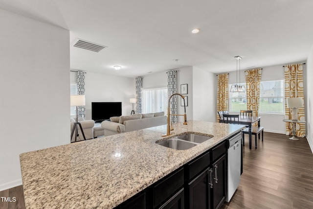 133 Ogden Pond Pl, Zebulon, NC 27597 - kitchen with stainless steel dishwasher, dark cabinetry, a kitchen island with sink, healthy amount of natural light, and recessed lighting