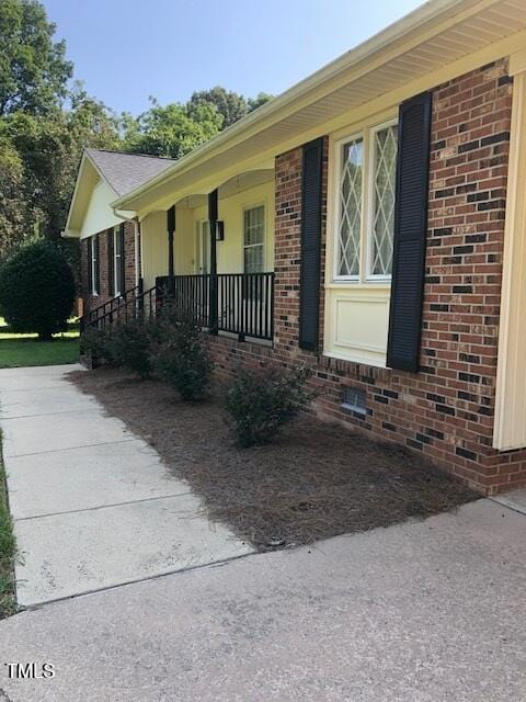 5018 Gatewood Dr, Durham, NC 27712 - view of side of home featuring brick siding and covered porch