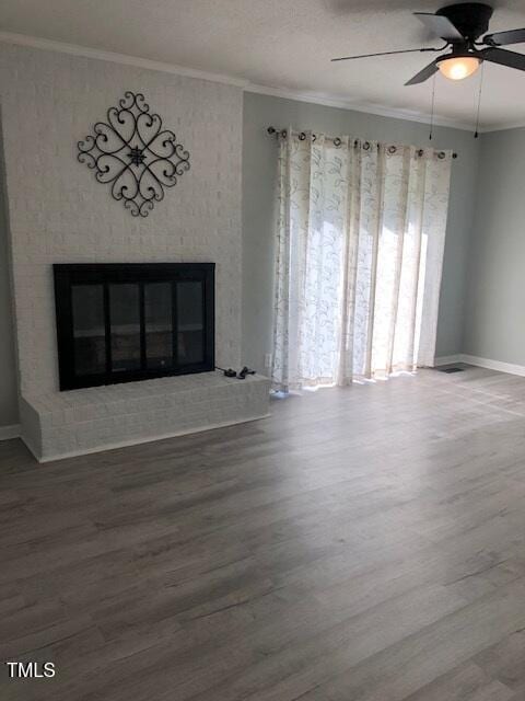 5018 Gatewood Dr, Durham, NC 27712 - unfurnished living room featuring a fireplace, a ceiling fan, wood finished floors, and crown molding