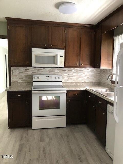 5018 Gatewood Dr, Durham, NC 27712 - kitchen with white appliances, tasteful backsplash, light countertops, and light wood-style floors