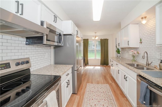 2517 Previs Rd, Fayetteville, NC 28306 - kitchen featuring appliances with stainless steel finishes, extractor fan, light wood-style floors, and white cabinetry