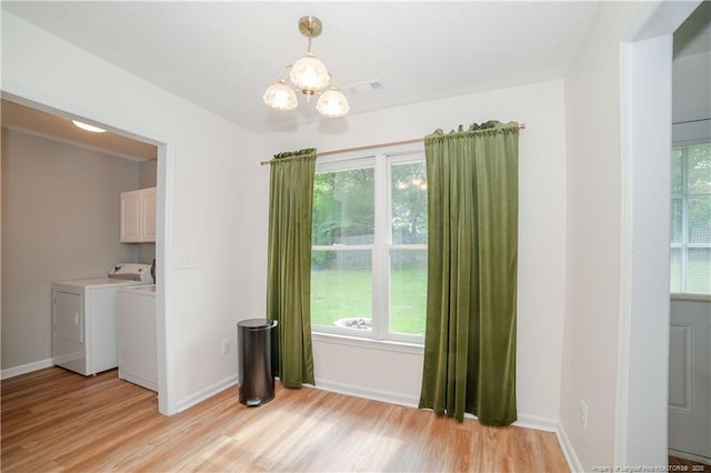 2517 Previs Rd, Fayetteville, NC 28306 - spare room with washing machine and dryer, light wood-style flooring, and a chandelier