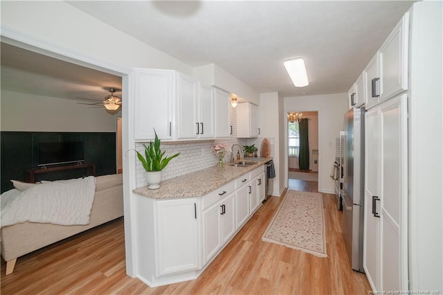 2517 Previs Rd, Fayetteville, NC 28306 - kitchen with light wood-type flooring, white cabinetry, backsplash, a chandelier, and open floor plan