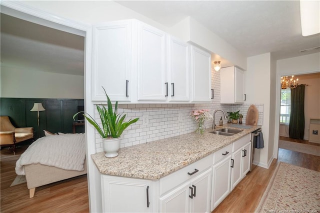 2517 Previs Rd, Fayetteville, NC 28306 - kitchen featuring a chandelier, light wood-style floors, white cabinetry, and backsplash