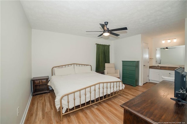 2517 Previs Rd, Fayetteville, NC 28306 - bedroom with light wood-style floors, ensuite bath, a ceiling fan, and a textured ceiling