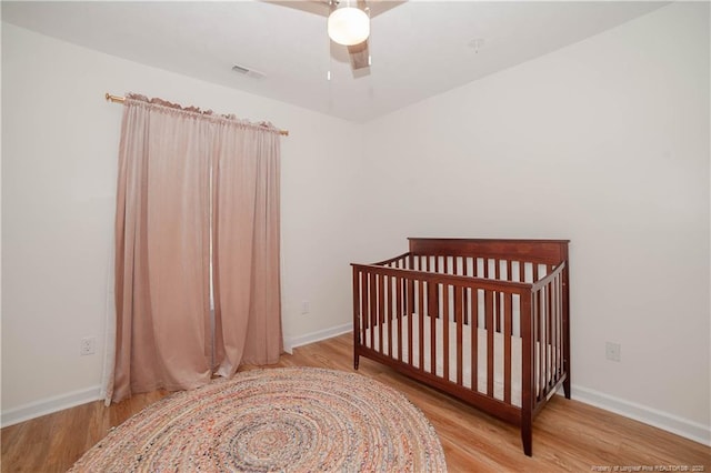 2517 Previs Rd, Fayetteville, NC 28306 - bedroom featuring wood finished floors, ceiling fan, and a crib