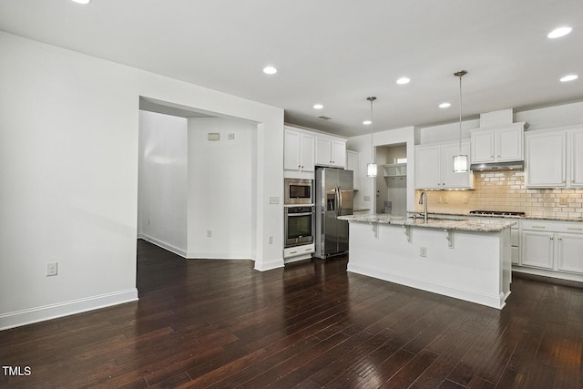 261 Begen St, Morrisville, NC 27560 - kitchen with appliances with stainless steel finishes, recessed lighting, decorative backsplash, a kitchen bar, and light stone counters