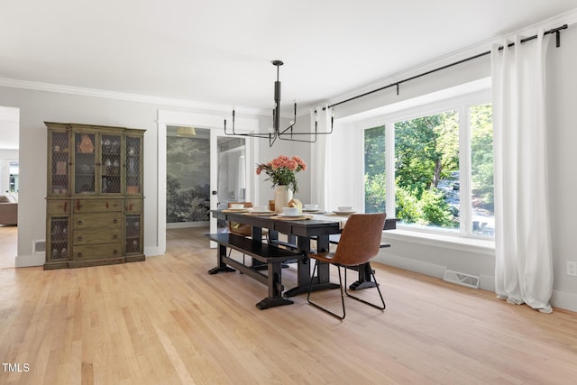 317 Reade Rd, Chapel Hill, NC 27516 - dining area featuring a chandelier, light wood finished floors, and crown molding