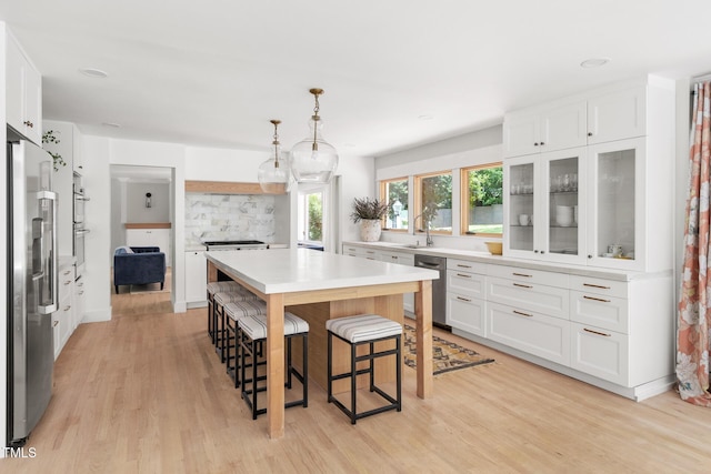 317 Reade Rd, Chapel Hill, NC 27516 - kitchen featuring stainless steel appliances, light wood-style floors, a kitchen breakfast bar, and white cabinetry