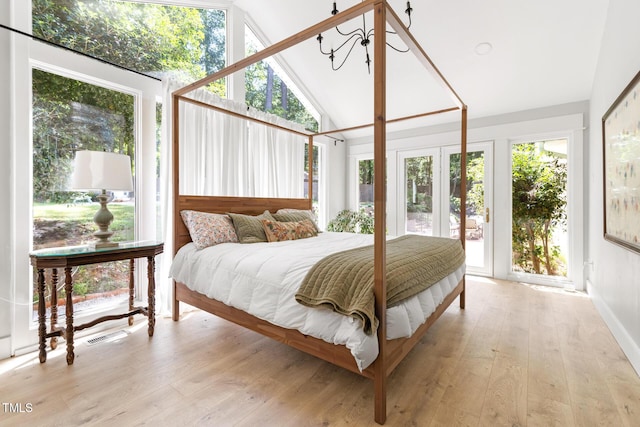 317 Reade Rd, Chapel Hill, NC 27516 - bedroom with lofted ceiling, wood finished floors, access to outside, and a chandelier