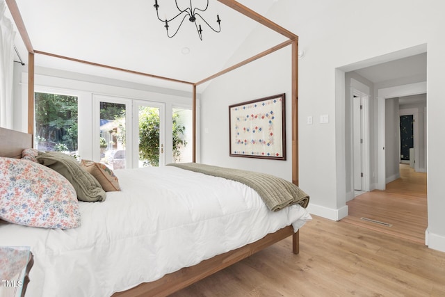 317 Reade Rd, Chapel Hill, NC 27516 - bedroom with light wood-style flooring, a chandelier, and high vaulted ceiling