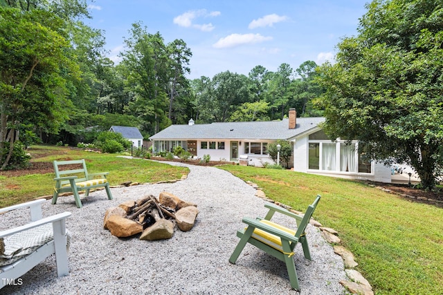 317 Reade Rd, Chapel Hill, NC 27516 - back of house featuring an outdoor fire pit, a lawn, and a chimney