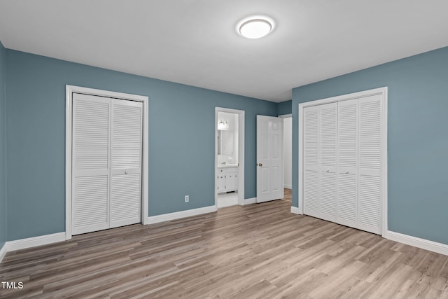 5313 Falkirk Dr, Durham, NC 27712 - unfurnished bedroom featuring wood finished floors, two closets, and connected bathroom