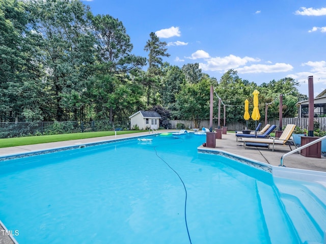171 Winding Oak Way, Clayton, NC 27520 - view of swimming pool featuring a patio area, view of scattered trees, and an outdoor structure
