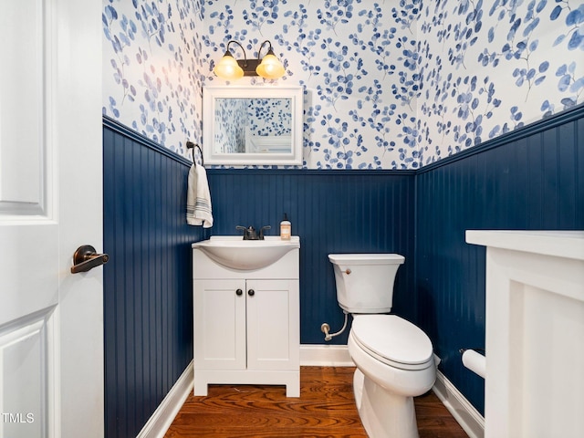 171 Winding Oak Way, Clayton, NC 27520 - half bathroom featuring vanity, wood finished floors, wallpapered walls, and wainscoting
