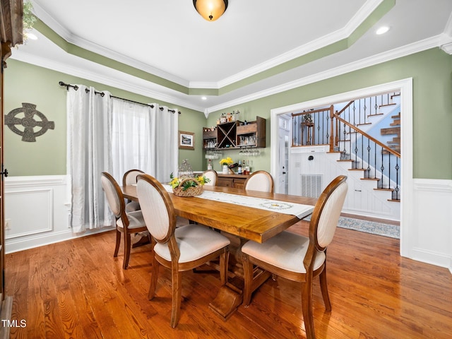 171 Winding Oak Way, Clayton, NC 27520 - dining area featuring stairway, wainscoting, wood finished floors, a raised ceiling, and ornamental molding