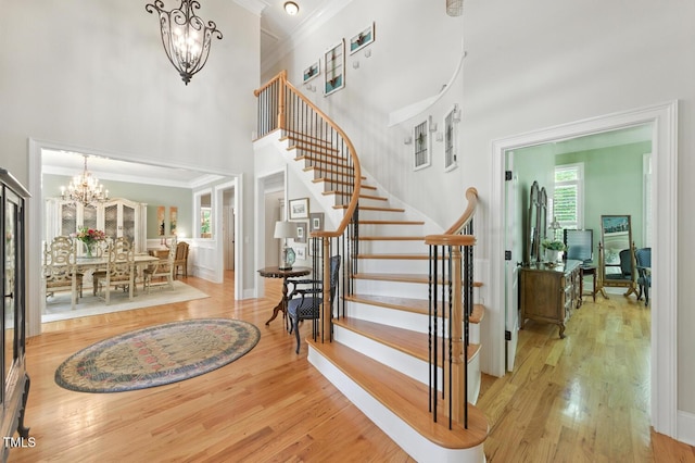 137 Forked Pine Ct, Chapel Hill, NC 27517 - stairs featuring a chandelier, a high ceiling, wood finished floors, and ornamental molding