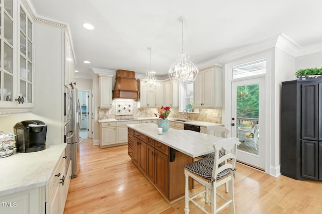 137 Forked Pine Ct, Chapel Hill, NC 27517 - kitchen featuring a chandelier, a center island, decorative backsplash, light wood finished floors, and a kitchen bar