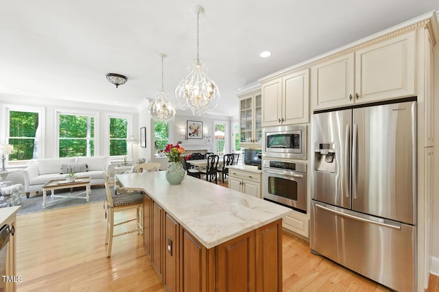 137 Forked Pine Ct, Chapel Hill, NC 27517 - kitchen with appliances with stainless steel finishes, a chandelier, light wood finished floors, glass insert cabinets, and cream cabinetry