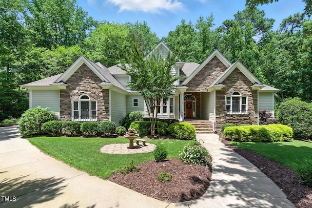 137 Forked Pine Ct, Chapel Hill, NC 27517 - craftsman-style house featuring stone siding, a front lawn, roof with shingles, and covered porch