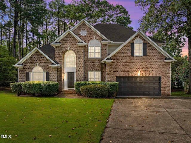 3608 Smoky Chestnut Ln, Raleigh, NC 27615 - traditional home with an attached garage, a front lawn, driveway, and brick siding