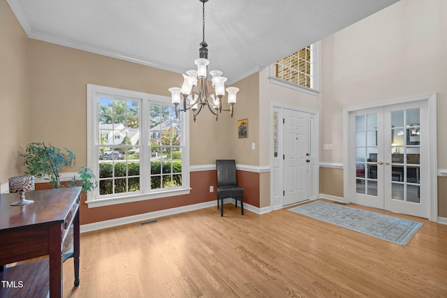 3608 Smoky Chestnut Ln, Raleigh, NC 27615 - foyer entrance with a chandelier, wood finished floors, ornamental molding, and french doors