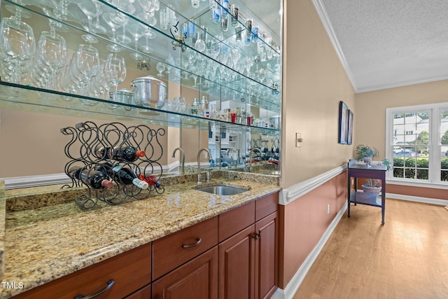 3608 Smoky Chestnut Ln, Raleigh, NC 27615 - indoor wet bar with ornamental molding, light wood-type flooring, and a textured ceiling
