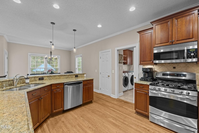 3608 Smoky Chestnut Ln, Raleigh, NC 27615 - kitchen featuring appliances with stainless steel finishes, independent washer and dryer, crown molding, light wood-type flooring, and a chandelier
