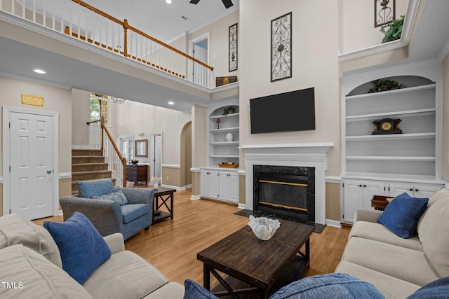 3608 Smoky Chestnut Ln, Raleigh, NC 27615 - living area with arched walkways, stairs, built in features, a premium fireplace, and a high ceiling