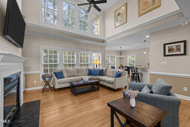 3608 Smoky Chestnut Ln, Raleigh, NC 27615 - living room featuring ceiling fan, crown molding, a fireplace, a high ceiling, and light wood-type flooring