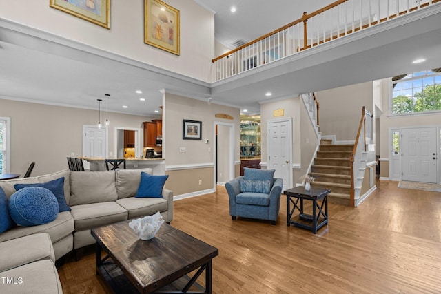 3608 Smoky Chestnut Ln, Raleigh, NC 27615 - living room with a high ceiling, light wood-style floors, stairway, crown molding, and recessed lighting