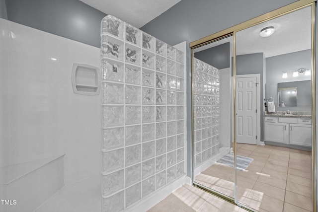 3608 Smoky Chestnut Ln, Raleigh, NC 27615 - bathroom featuring walk in shower, vanity, tile patterned floors, and a textured ceiling