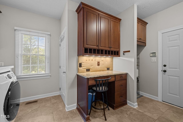 3608 Smoky Chestnut Ln, Raleigh, NC 27615 - laundry area featuring washer / clothes dryer, cabinet space, light tile patterned floors, and a desk