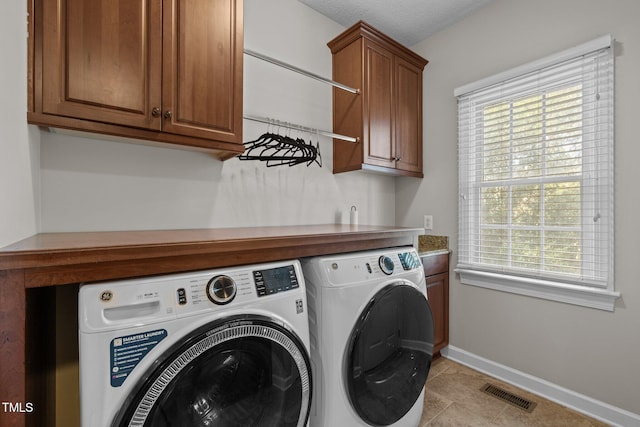 3608 Smoky Chestnut Ln, Raleigh, NC 27615 - laundry area featuring cabinet space, washing machine and clothes dryer, healthy amount of natural light, and light tile patterned floors