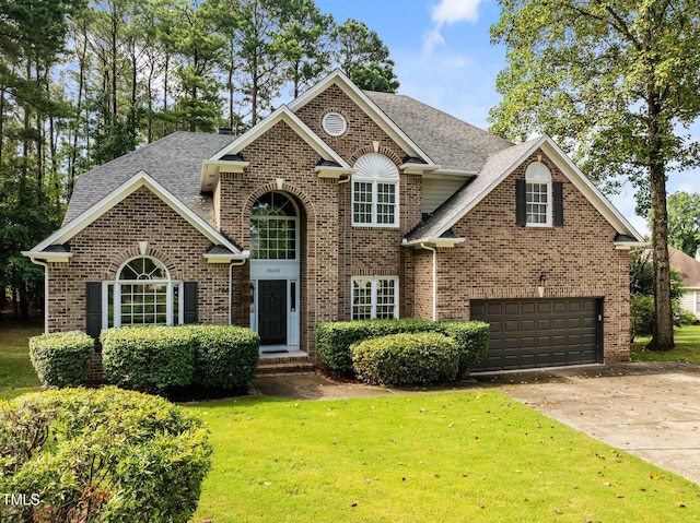 3608 Smoky Chestnut Ln, Raleigh, NC 27615 - traditional home with brick siding, a front lawn, an attached garage, and driveway